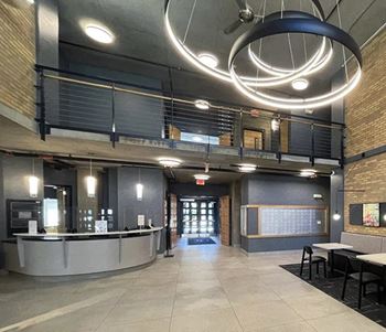 a large lobby with tables and chairs and a chandelier